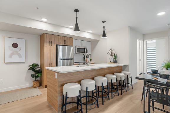an open kitchen and dining area with a bar and stools