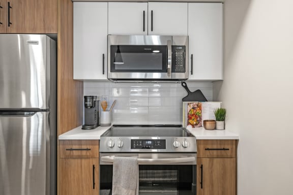 a modern kitchen with stainless steel appliances and white cabinets