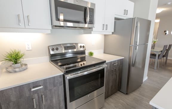 A modern kitchen with stainless steel appliances and white cabinets.