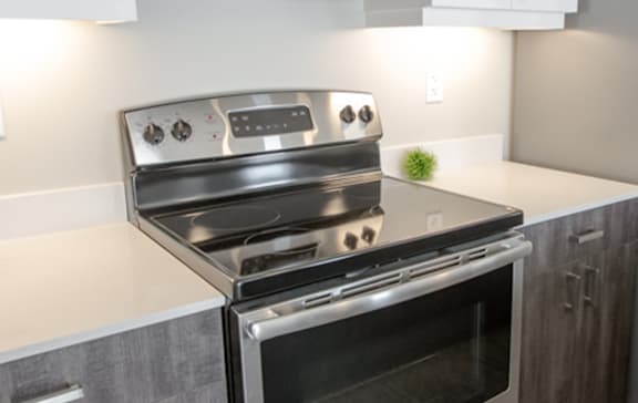 A modern kitchen with a black countertop and white cabinets.