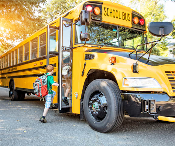 Yellow school bus with student boarding at Mac and Mullen Apartments, Edmonton, Alberta