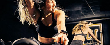 Two women are working out in a gym.