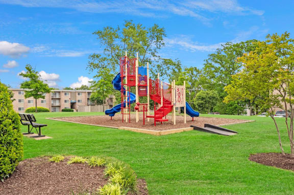 A playground with a red slide and a blue slide at Andrews Ridge Apartments, Suitland, MD