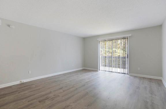 A room with wooden flooring and a window with blinds at The Onyx Hoover Apartments, Alabama