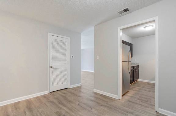 A room with a white door and a kitchen area in the background at The Onyx Hoover Apartments, Hoover