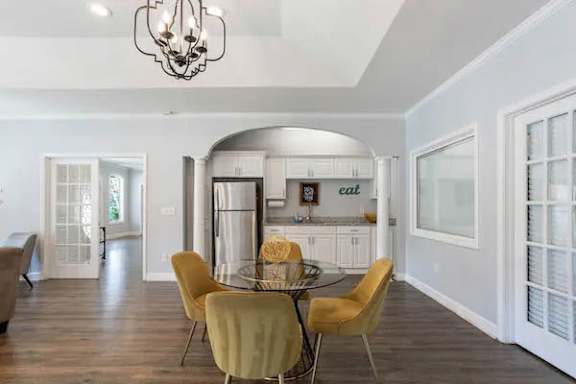 A dining room with a glass table and yellow chairs at The Onyx Hoover Apartments, Hoover, AL, 35216