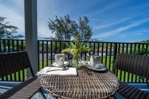 a table with a vase of flowers on a balcony at Piper Village West, Florida