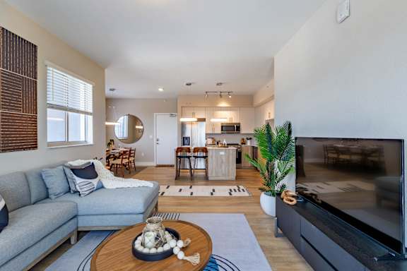 A modern living room with a grey sofa, a wooden coffee table, and a large flat screen TV.at Icon One, Daytona Beach