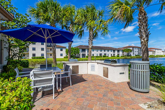 Patio with BBQ and blue umbrella at Portofino Cove, Fort Myers, FL, 33916