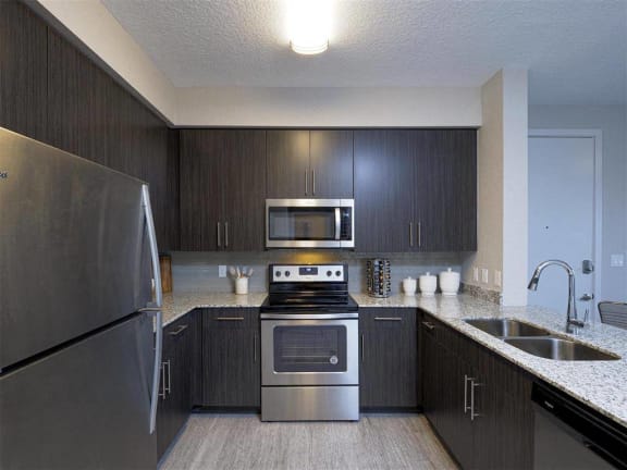 a kitchen with stainless steel appliances and a sink at Icon One, Daytona Beach, FL, 32114