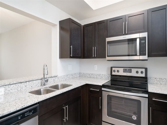 a kitchen with a stove microwave and sink at Portofino Cove