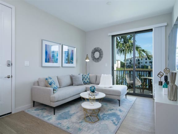 a living room with a couch and a table in front of a window