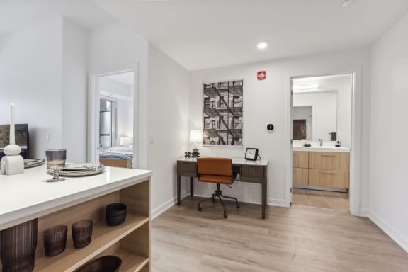 a home office with a desk with a chair and a mirror