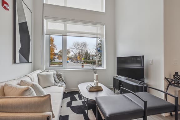 a living room with a couch and a tv and a window