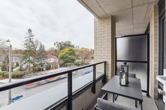 a balcony with a table and chairs and a large window