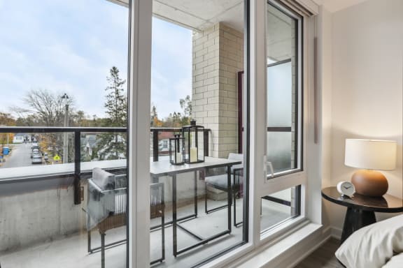 a bedroom with a large window and a balcony