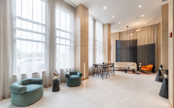 a lobby with large windows and chairs and a couch