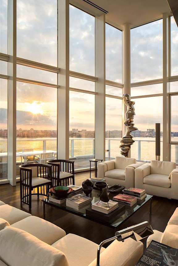 a living room with a view of the water and a couch and a table