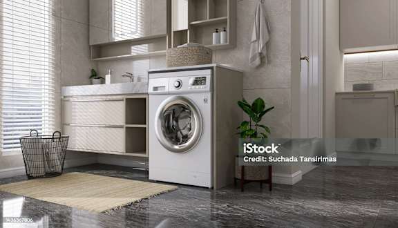 a washing machine in a kitchen with a sink and a window