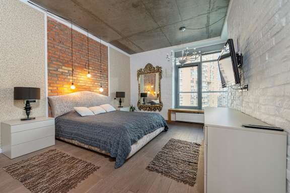 A bedroom with a bed, a dresser, and a mirror.