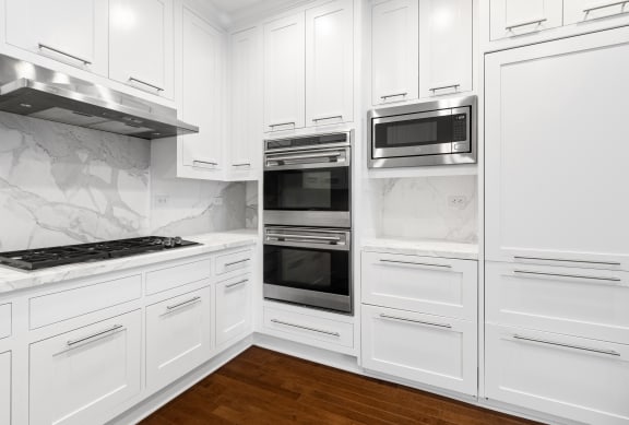 a kitchen with white cabinets and stainless steel appliances at HIGHGROVE, Stamford, CT