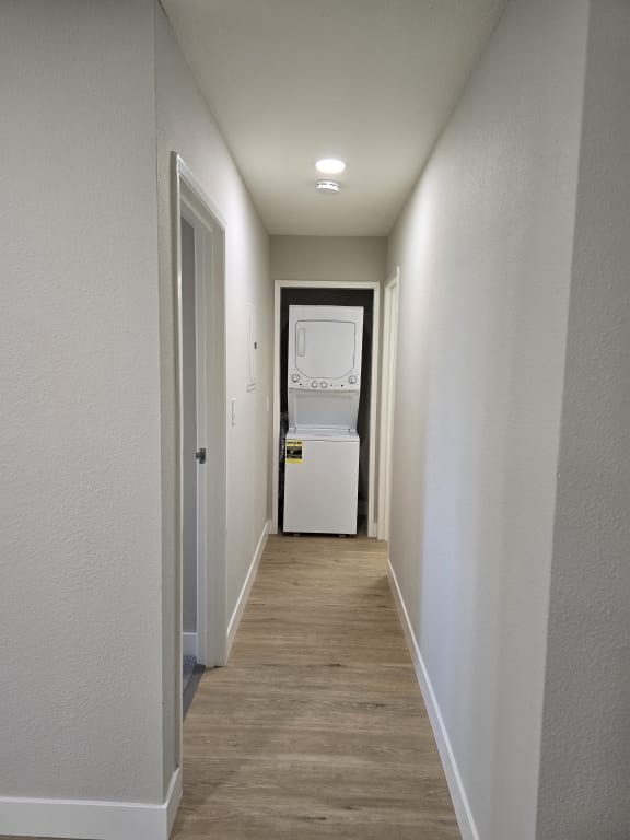 a hallway leading to a laundry room with a washer and dryer