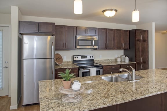 Stainless steel appliances in a modern kitchen with granite countertops.