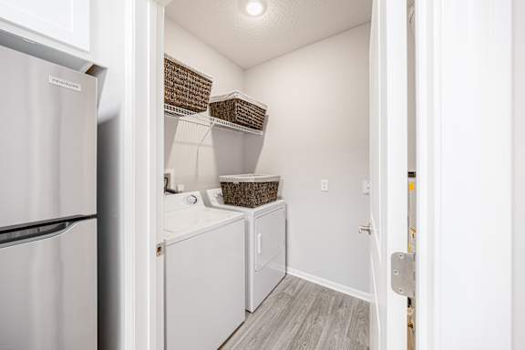 A white refrigerator is on the left of a small kitchen.