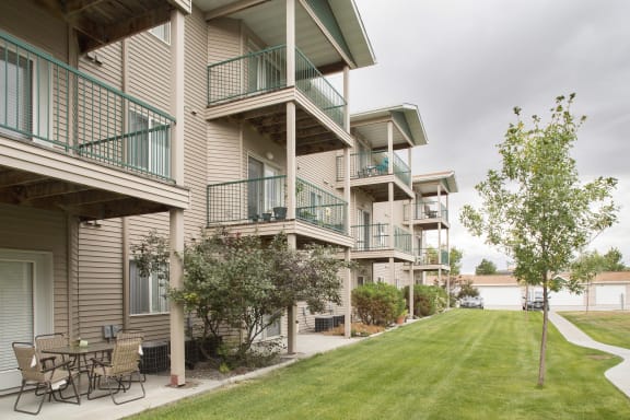 Exterior of Country Meadows Apartment Homes showcasing private balconies and patios as well as the lush green grounds.