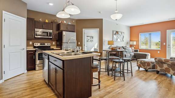 A modern kitchen with a large island and a dining area.