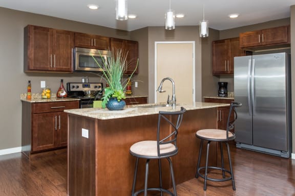Full kitchen with dark wood cabinets and central island with barstools