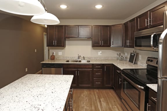 Kitchen with dark wood cabinets, stainless steel appliances and granite counter tops