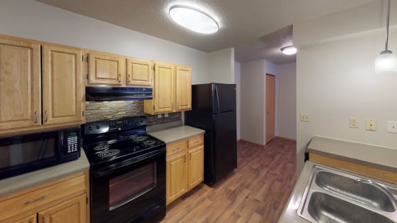 Kitchen with black appliances and tile backsplash.