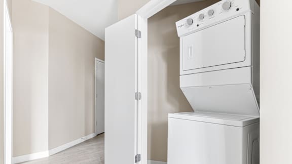 an empty laundry room with a washer and dryer in it