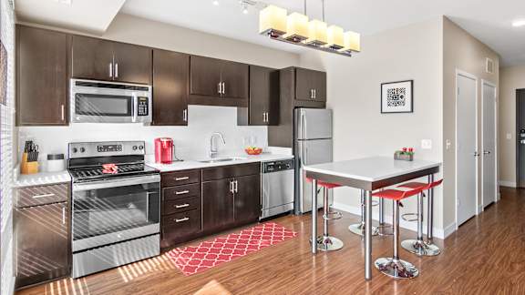 a modern kitchen with stainless steel appliances and a white counter top