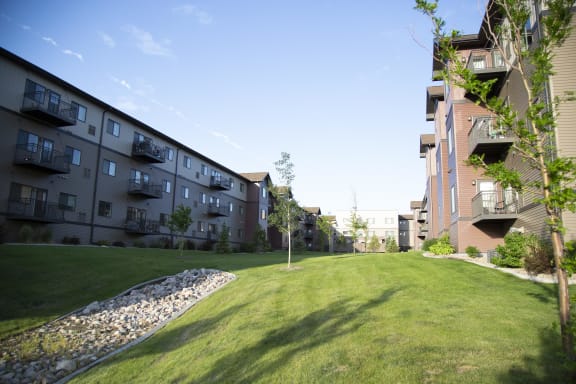 Expansive view of the courtyard at River Ridge Apartment Homes. Exterior of the building shows the private balconies and patios.