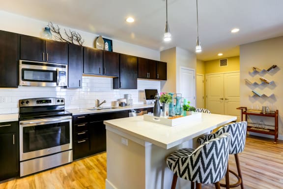 Modern and spacious kitchen with stainless steel appliances and an eat-in kitchen island.