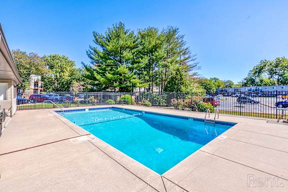 A swimming pool surrounded by a fence and trees.