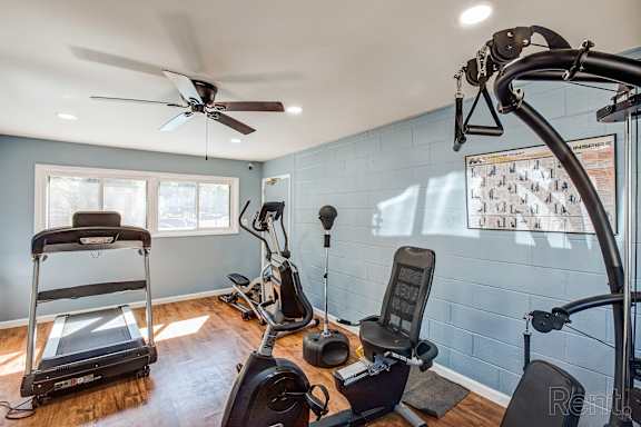 A home gym with a treadmill, exercise bike, and other equipment.
