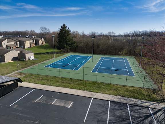 an aerial view of a tennis court with two tennis courts on a green tennis court