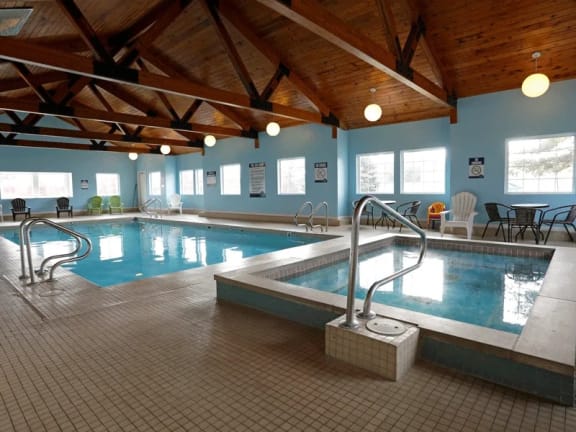 a large indoor swimming pool with a wooden ceiling