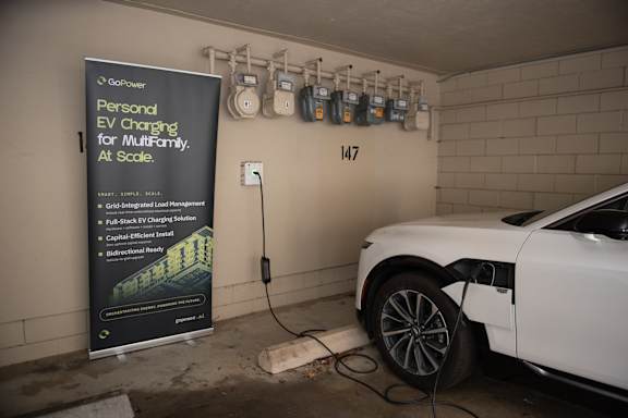 A white car is charging in a garage with a GoPower sign.
