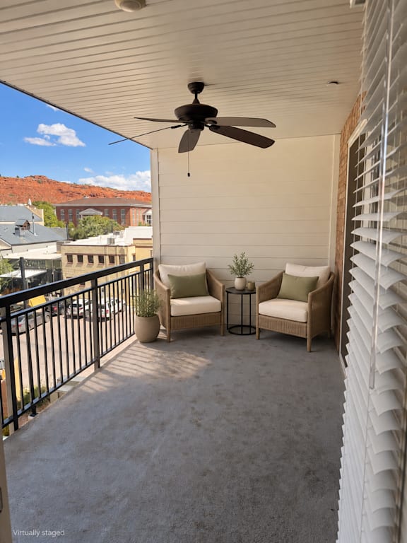 A patio with a ceiling fan and a table with chairs.