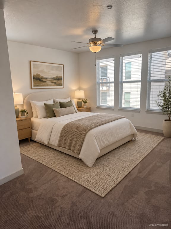 A bedroom with a large bed and a ceiling fan.