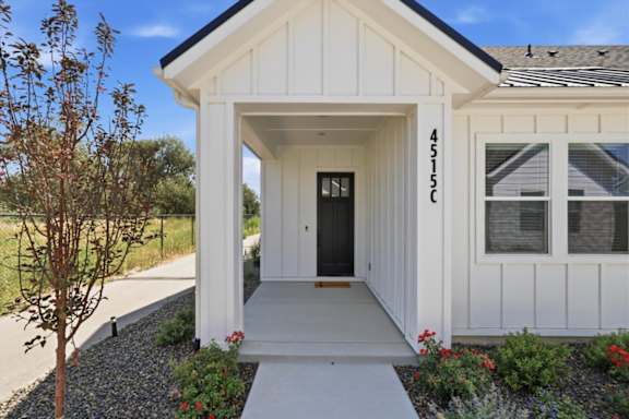 A white house with a black door and windows.
