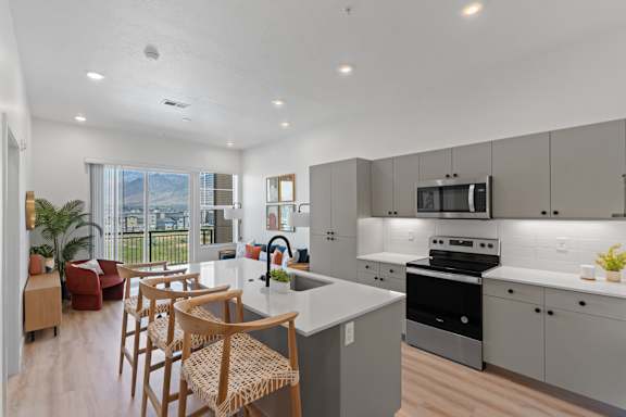 A modern kitchen with a dining area and a balcony.