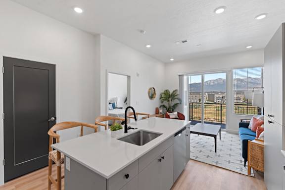 A modern kitchen with a large island and a view of the city.