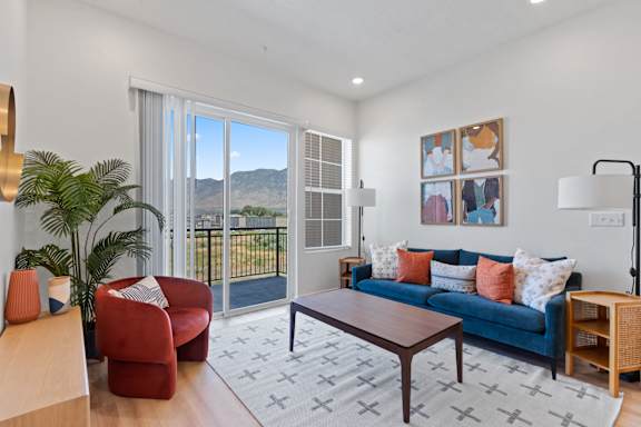 A living room with a blue couch and a red chair.