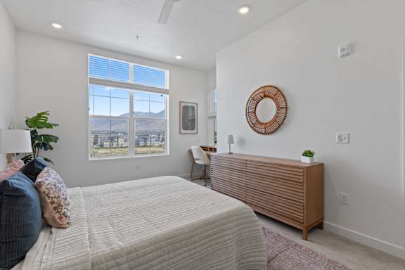 A bedroom with a large bed and a view of the mountains through the window.