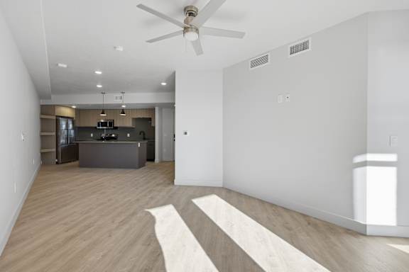Large empty room with kitchen view at Brickside Heights, Millcreek, UT, 84106